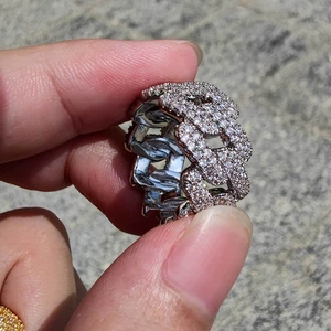 Dettaglio anello hip hop a maglia cubana argento con zirconi tenuto in mano all'aperto