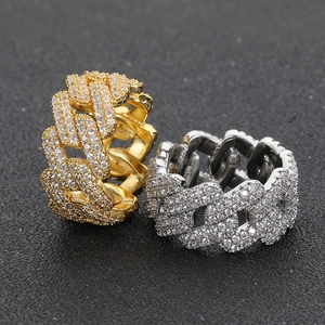 Dettaglio macro di anelli a maglia cubana color oro e argento con zirconi incastonati