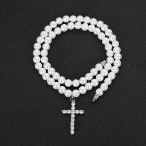 Double-layered pearl necklace with a sparkling diamond-encrusted cross pendant for unisex wear