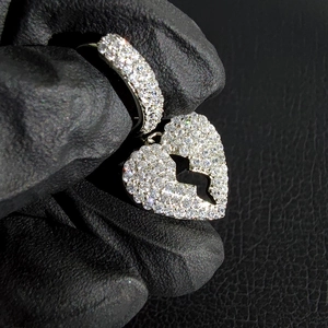 Macro-opname van zilveren hiphop gebroken hart oorbel met micro-pave zirkonia steentjes