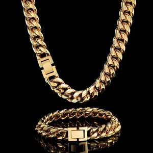 Close-up of golden Cuban link necklace and bracelet set with rectangle buckles