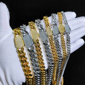 Close-up of gold and silver Cuban chain links with paved zircon spring box clasps