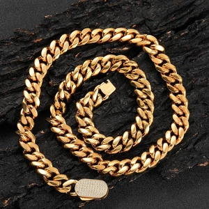 Golden Cuban link necklace with iced out zircon spring clasp on black textured background