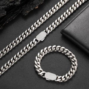 Detailed shot of silver-tone Cuban link necklace and bracelet set with square clasp