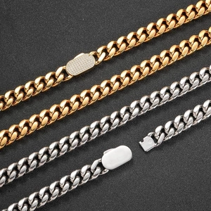 Macro view of gold and silver Cuban link chains with pavé set zircon spring clasp detail