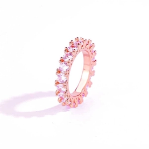 Detail view of rose gold band with round pink cubic zirconia stones in a prong setting