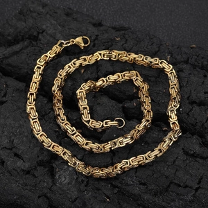 Macro shot of 4mm gold Byzantine chain on dark stone showing texture and lobster clasp