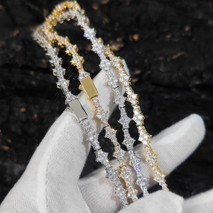 Close-up of gold and silver tennis necklaces with iced out star links and box clasps
