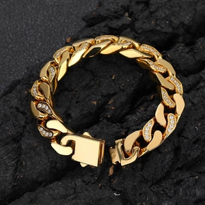 Detail shot of a 12mm gold Cuban link bracelet with cubic zirconia on black rock