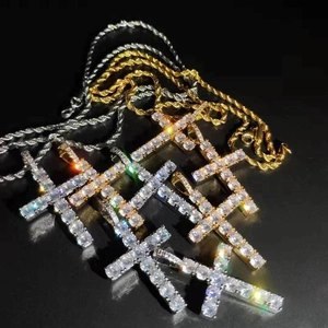 Dettaglio di ciondoli a croce hip hop in oro e argento con pavé di zirconi su catene a corda