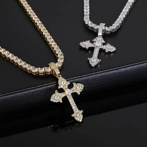 Dettaglio macro dei ciondoli a croce hip hop in oro e argento con catene da tennis