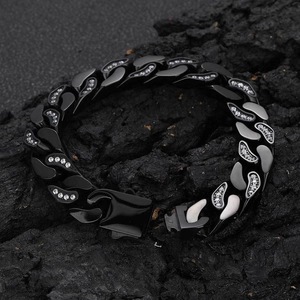 Detail view of 12mm black Cuban link bracelet with CNC set zircon stones on dark rock