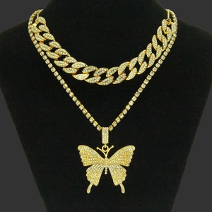 Detail of iced out gold double layer butterfly necklace set on black velvet display