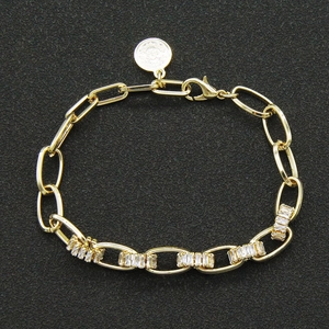 Elegante gouden schakelarmband met zirkonia inleg en ronde munt hanger voor dames