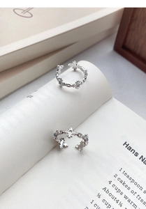 Detailed view of silver iris flower rings with white agate on open book pages