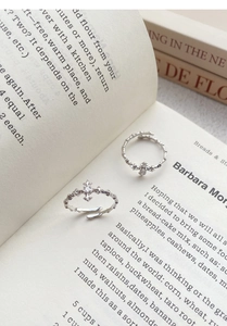 Close-up of S925 sterling silver star cross rings with zircon stones on an open book