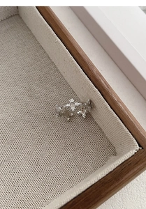 Detailed view of S925 silver ring featuring a cross and white agate on linen tray