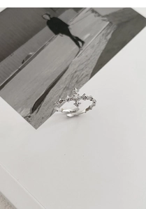 Macro shot of silver gothic cross ring with zircon stone and thorn texture detailing