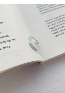 Nahaufnahme des S999 Sterlingsilber Pfirsichblütenrings auf Buchseiten als Geschenk