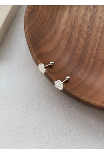 Detailed close-up of S999 silver cat paw and fish stud earrings with secure screw backs