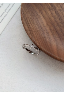 Macro shot of silver S925 ring with carved floral patterns and round white zircon detail
