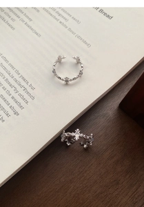 Close-up of vintage S925 silver cross rings with white agate stones on an antique book