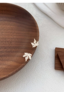 Gros plan détaillé des boucles d'oreilles en argent S999 en forme de feuille d'érable