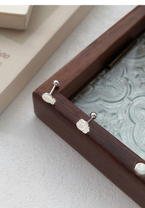 Detailed close-up of cute silver cat paw and fish studs with secure screw ball backs