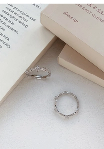 Detail of vintage silver hollow rings with sparkling crystals and retro carvings