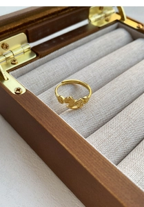Macro shot of gold S999 silver horse and coin ring inside a premium wooden jewelry box