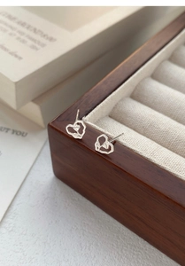Detailed view of S999 sterling silver rose heart earrings on luxury jewelry box display