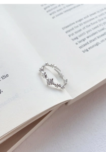 Close-up of S925 sterling silver cross zircon ring on vintage book pages