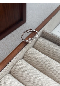 Macro detail of S925 sterling silver star ring on wood box with thorn texture