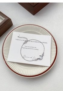 Close-up of S999 silver star and moon bracelet with pearl shell on a gift card