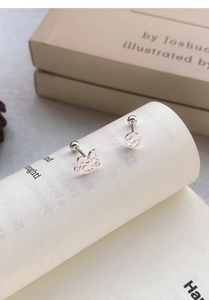 Détail de boucles d'oreilles S999 en argent avec cheval à bascule et pièce évidée