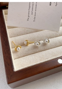 Detail von eleganten Perlenohrsteckern mit Gold- und Silberrahmen auf Samtfutter