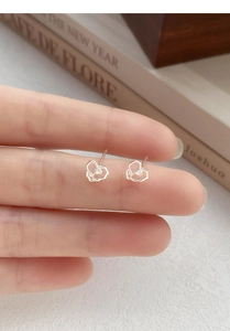 Detailed close-up of S999 silver hollow heart studs with intricate rose flower center design