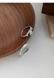 Detailansicht von Silberringen mit Pfirsichblütendesign und blauem Emailleschmuck