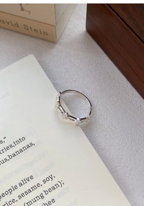 Détail de la bague double couche en argent avec fleurs en zircon sur le bord du livre
