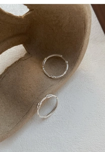 Dettaglio dell'anello in argento S999 con design a corda intrecciata e superficie liscia