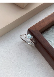 Detailaufnahme des S999 Silberrings mit blauer Emailleblume und Edelsteinen