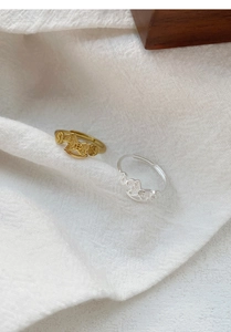 Detail view of gold and silver S999 animal rings with traditional coin motifs and open bands