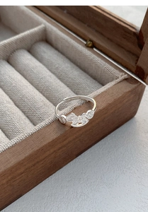 Macro detail of S999 sterling silver horse ring with coin pattern on a wooden box