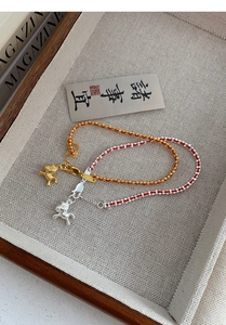 Détail des pendentifs cheval en argent S925 sur bracelets cordon rouge avec fermoir mousqueton
