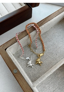 Détail de charms cheval en argent S925 sur cordes tressées rouges dans un présentoir