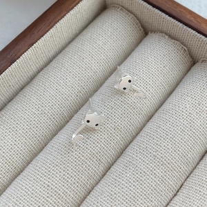 Boucles d'oreilles chat en argent sterling S999 sur une boîte à bijoux en lin beige