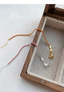 Gros plan de bracelets S925 en fil rouge avec des breloques de cheval en argent