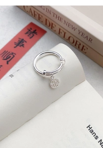 Macro detail of S925 sterling silver ring with adjustable band and lucky Fu character charm