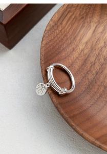 Macro shot of S925 sterling silver adjustable ring with Fu character circular charm