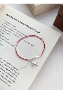 Vue détaillée du charm cheval en argent S925 sur un bracelet en cordon rouge tressé